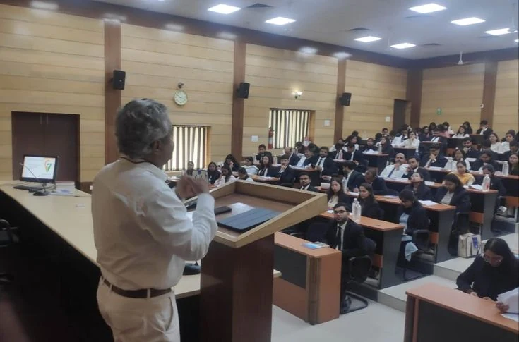 Faculty member addressing a full lecture hall